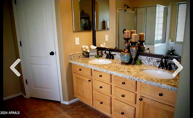 bathroom with tile patterned floors, vanity, and an enclosed shower