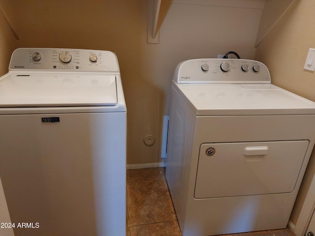 clothes washing area featuring light tile patterned floors and independent washer and dryer