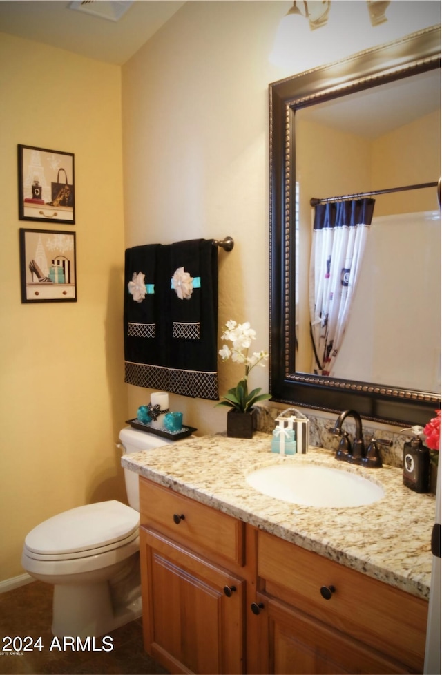 bathroom with vanity, toilet, and a shower