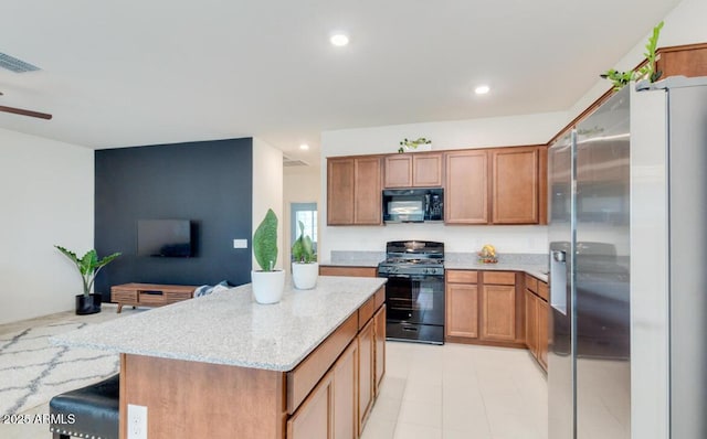 kitchen with visible vents, brown cabinets, black appliances, light stone counters, and recessed lighting