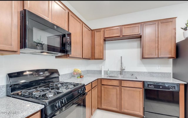 kitchen with brown cabinetry, light stone countertops, black appliances, and a sink