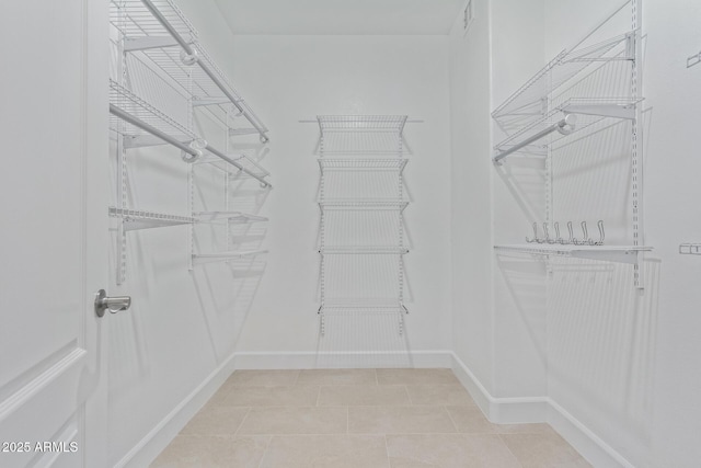 spacious closet with light tile patterned floors