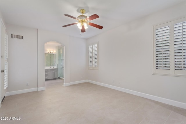 unfurnished bedroom featuring ceiling fan and ensuite bathroom