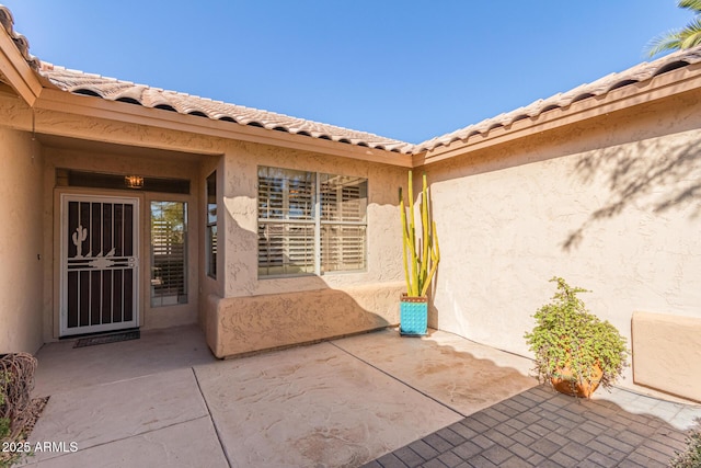 entrance to property featuring a patio area