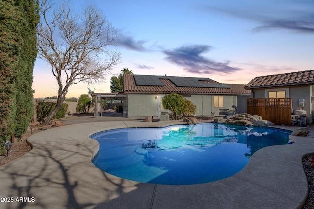 pool at dusk with a patio