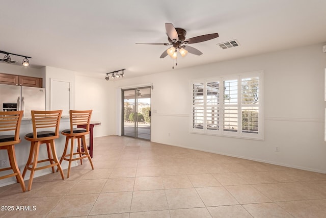 interior space with ceiling fan, light tile patterned floors, and track lighting