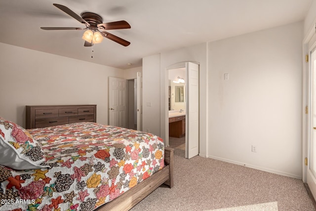 bedroom with ceiling fan, light carpet, and ensuite bath