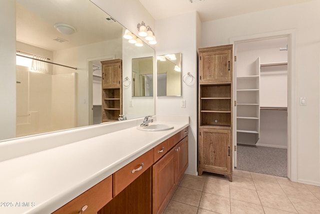 bathroom featuring a shower, vanity, and tile patterned flooring