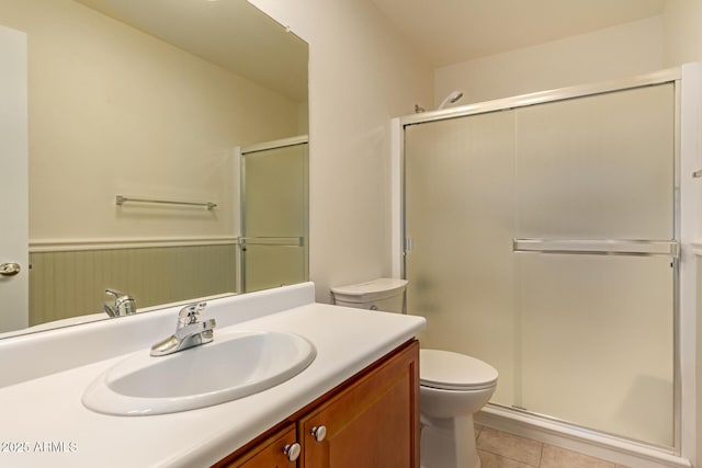 bathroom with toilet, tile patterned flooring, an enclosed shower, and vanity