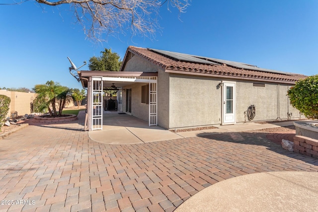 rear view of house featuring a patio and solar panels