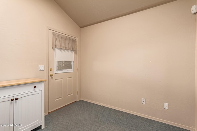 doorway featuring dark carpet and lofted ceiling