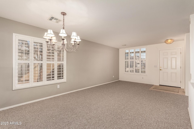 unfurnished room with an inviting chandelier and carpet floors