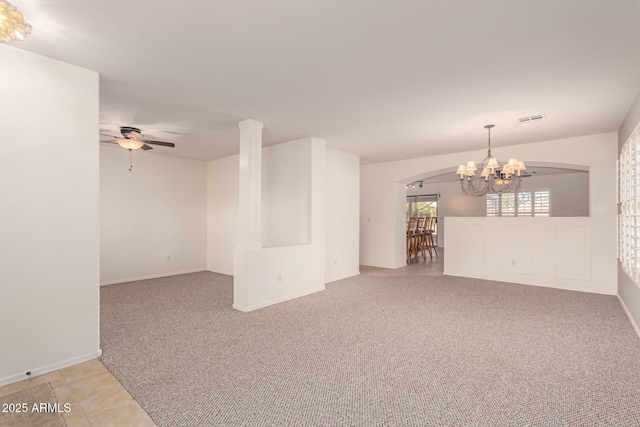 carpeted empty room featuring ceiling fan with notable chandelier