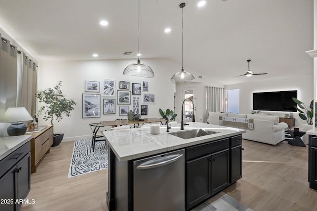 kitchen featuring visible vents, lofted ceiling, light wood-style flooring, stainless steel dishwasher, and a sink