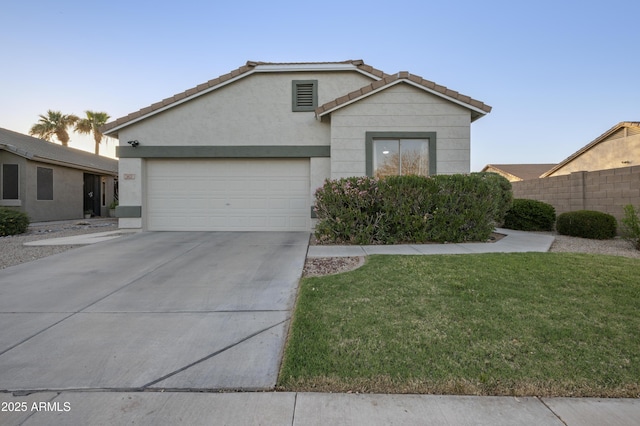 ranch-style home with driveway, an attached garage, stucco siding, a front lawn, and a tiled roof