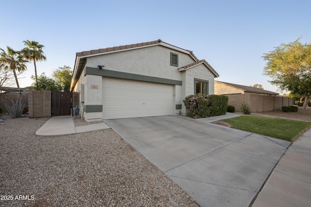 view of front of house featuring a gate, fence, a garage, and stucco siding