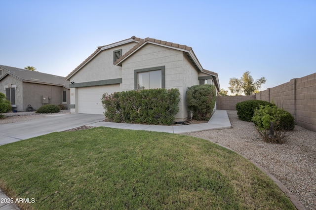 view of front facade with a front yard, fence, an attached garage, stucco siding, and concrete driveway