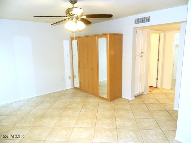 unfurnished room featuring visible vents, a ceiling fan, and light tile patterned floors