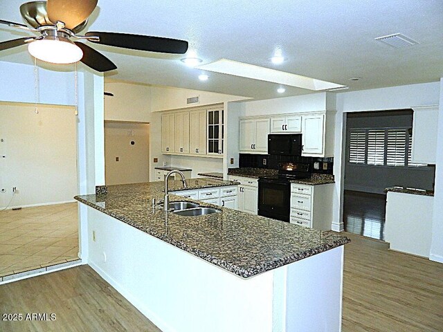 kitchen with a sink, black appliances, light wood-style floors, ceiling fan, and recessed lighting