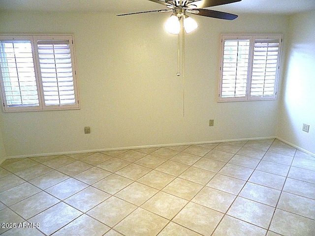 unfurnished room with ceiling fan, baseboards, and light tile patterned flooring