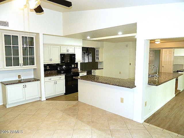 kitchen featuring a sink, electric range, visible vents, glass insert cabinets, and ceiling fan