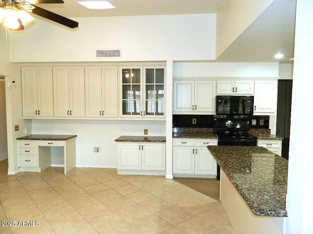 kitchen with black appliances, dark stone countertops, visible vents, and light tile patterned floors