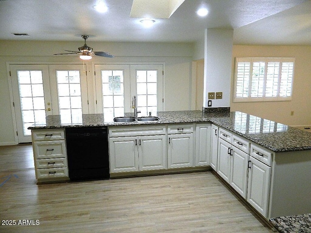 kitchen with a peninsula, a sink, visible vents, black dishwasher, and ceiling fan