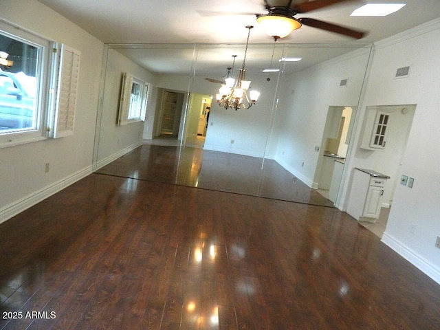 unfurnished dining area with baseboards, wood finished floors, visible vents, and ceiling fan with notable chandelier