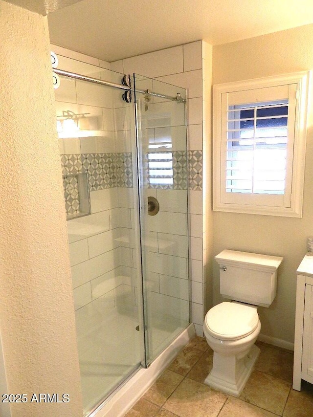bathroom with vanity, tile patterned flooring, a stall shower, and toilet