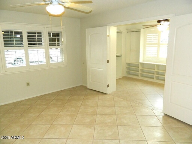 interior space featuring light tile patterned flooring and a ceiling fan