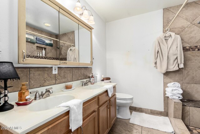 6908 W Sunnyside Dr, Peoria, AZ 85345 - bathroom featuring a tile shower, toilet, tile patterned floors, and double vanity