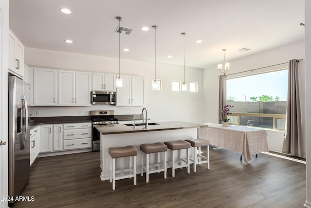 kitchen featuring appliances with stainless steel finishes, sink, pendant lighting, and white cabinets