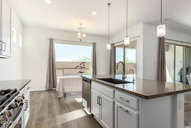 kitchen featuring an island with sink, wood-type flooring, stainless steel appliances, sink, and pendant lighting