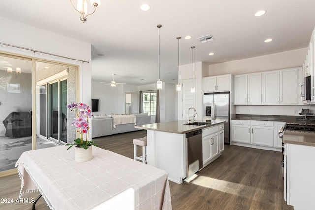 kitchen with white cabinetry, appliances with stainless steel finishes, an island with sink, and hanging light fixtures