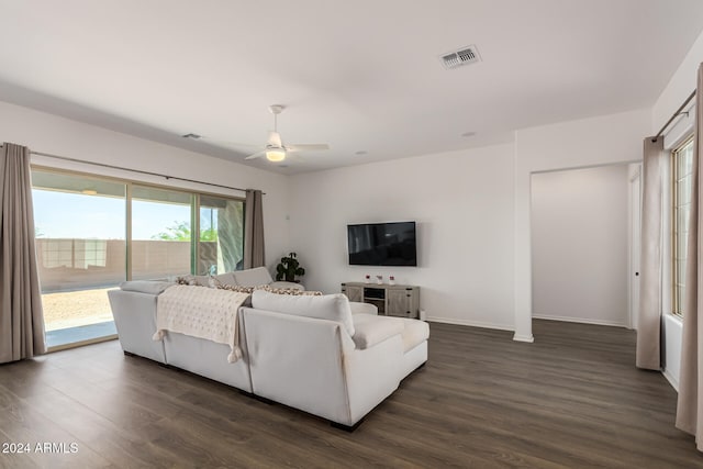 living room featuring dark wood-type flooring and ceiling fan