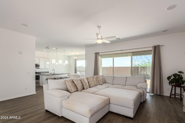 living room with ceiling fan and dark hardwood / wood-style flooring