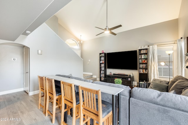 living room with ceiling fan, light wood-type flooring, and high vaulted ceiling