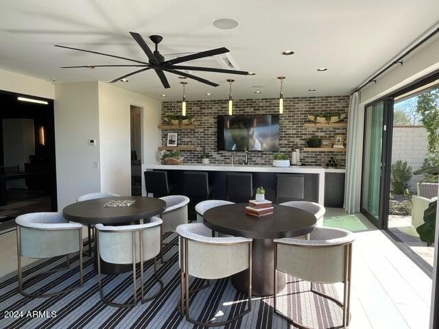 dining area featuring brick wall and ceiling fan