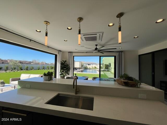 kitchen with ceiling fan, sink, and decorative light fixtures