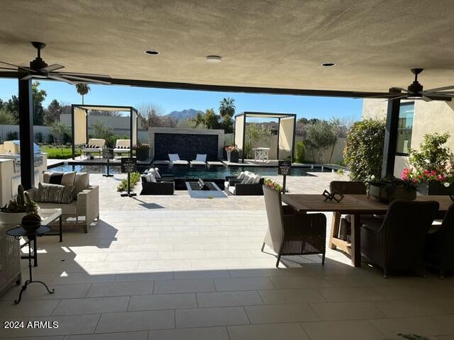 view of terrace with ceiling fan and a community pool