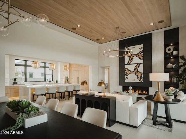 tiled dining area featuring a chandelier, wood ceiling, and a high ceiling