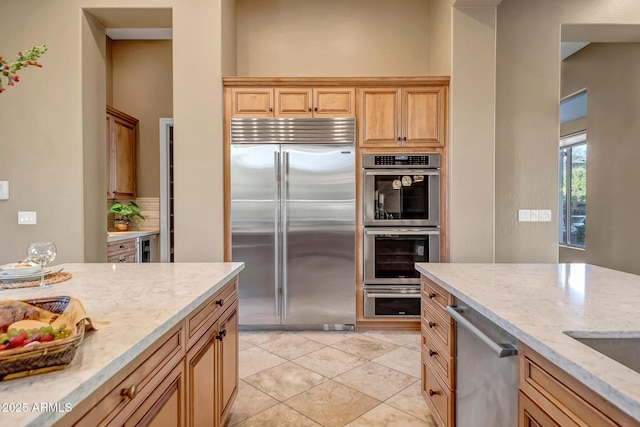 42023 N Bridlewood Way, Anthem, AZ 85086 - kitchen featuring appliances with stainless steel finishes, light stone countertops, and light tile patterned floors