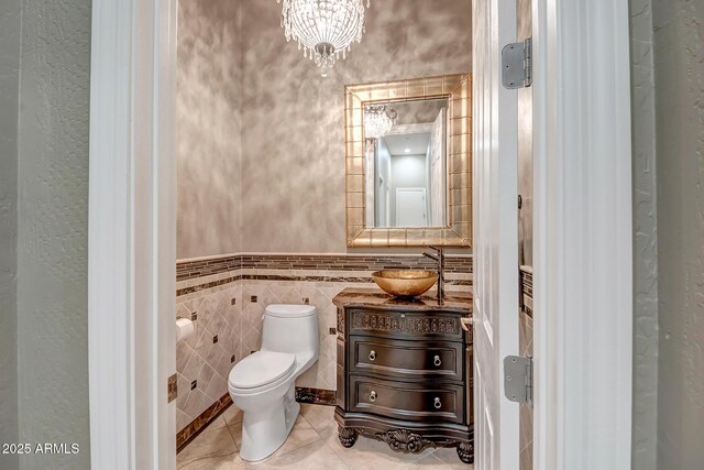 42023 N Bridlewood Way, Anthem, AZ 85086 - bathroom featuring toilet, a textured wall, vanity, tile walls, and tile patterned floors