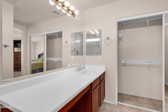 1623 E Maplewood Ave, Buckeye, AZ 85326 - bathroom featuring vanity, a walk in closet, and tile patterned floors