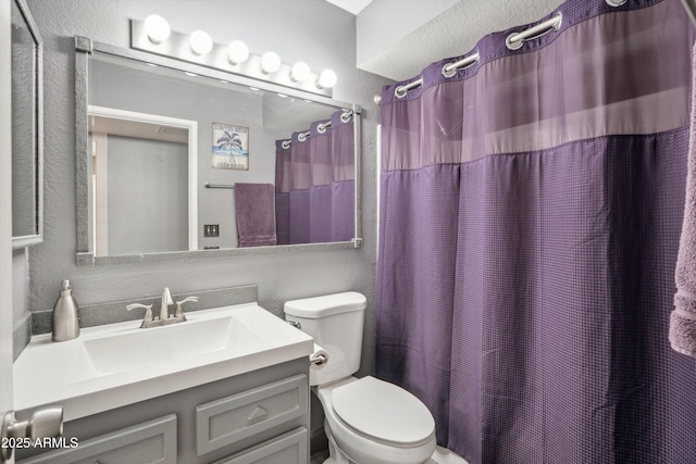 full bathroom with vanity, toilet, a textured wall, and a shower with curtain