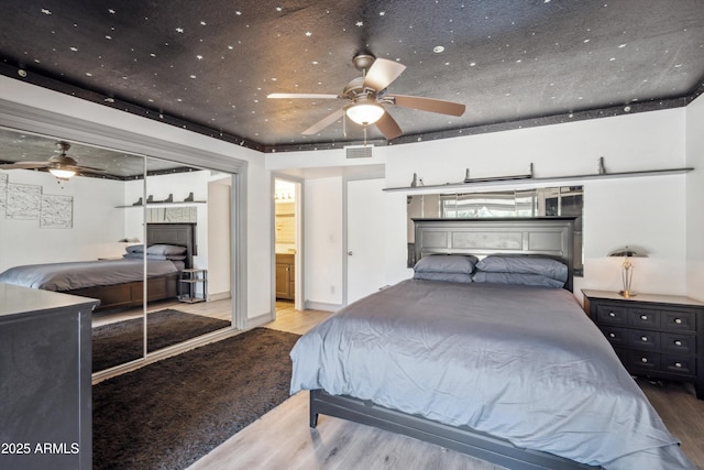 bedroom featuring a fireplace, visible vents, and wood finished floors