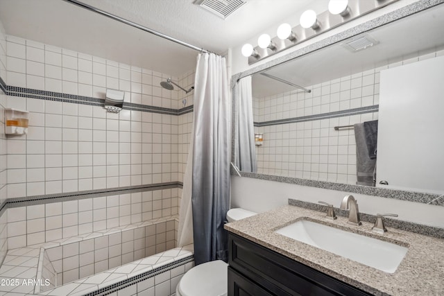 bathroom with vanity, toilet, tiled shower / bath, and visible vents