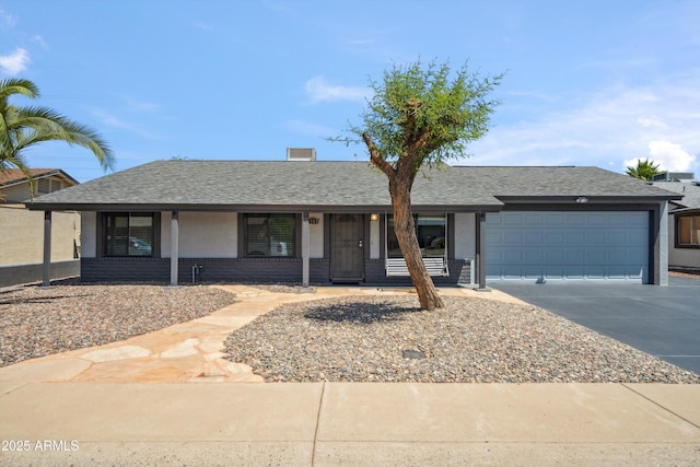 ranch-style home with an attached garage, a porch, driveway, and roof with shingles