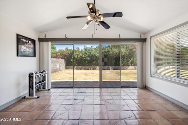 interior space with ceiling fan, lofted ceiling, and baseboards
