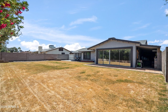 rear view of house with a yard, a patio area, and a fenced backyard